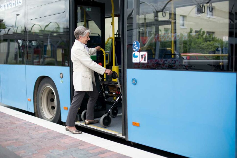Senioren mit Rollator steigt in einen Bus ein