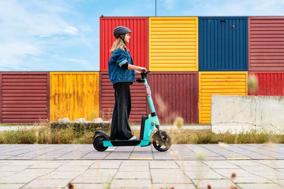 junge Frau auf einem e-Tretroller von dott